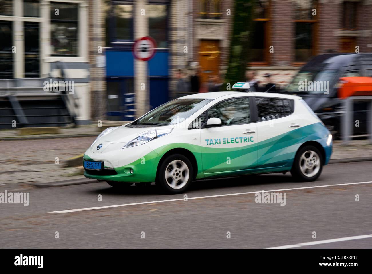AMSTERDAM, NETHERLANDS - NOVEMBER 8, 2013: Japanese Nissan Leaf electrical taxi car in Amsterdam, Netherlands. There are 25 of these electrical taxis Stock Photo