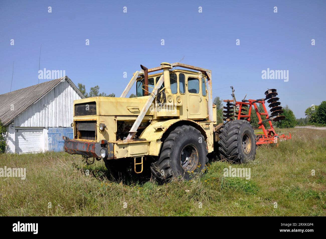 Old yellow Soviet tractor Kirovets K 700. Stock Photo