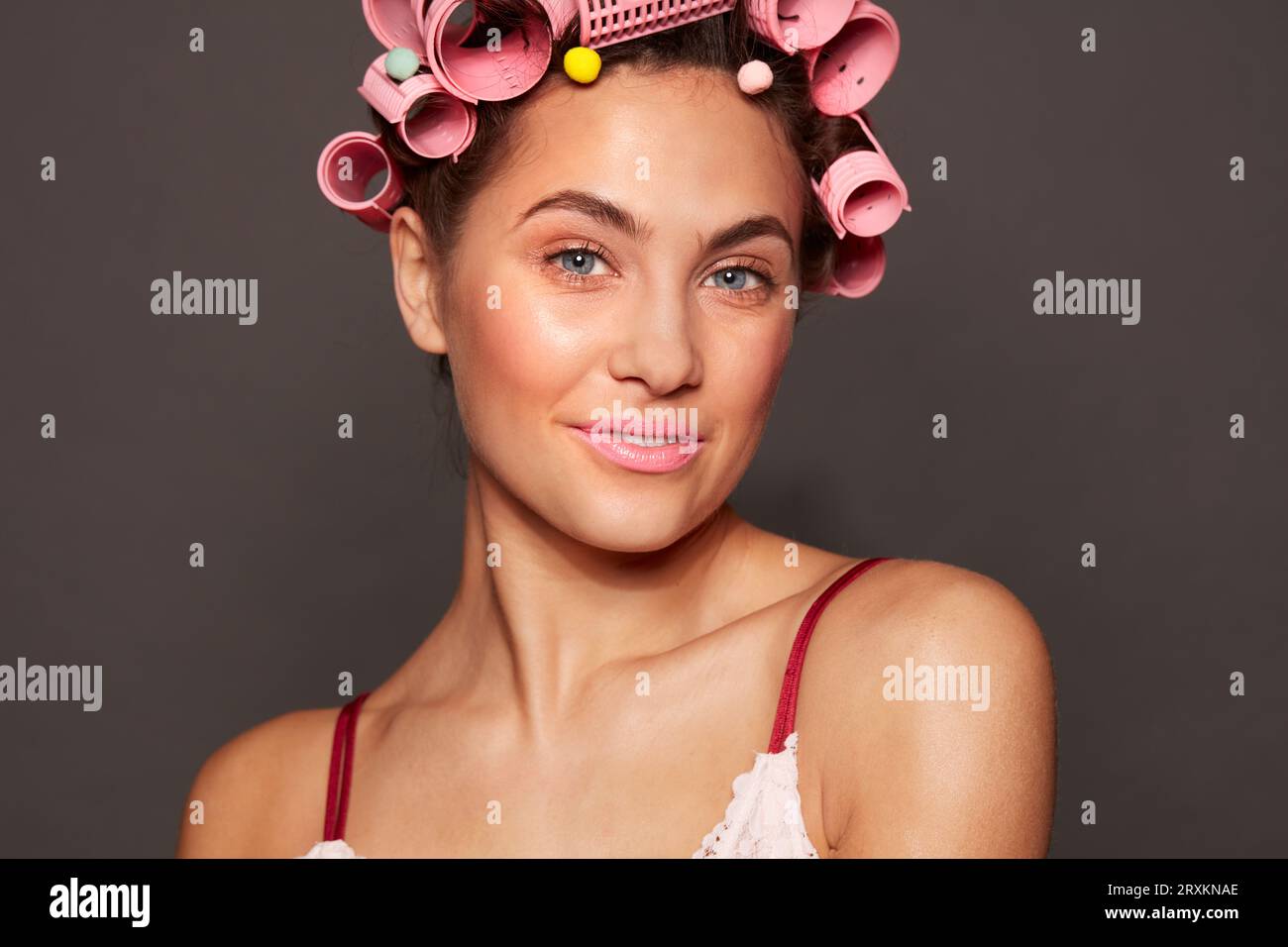 Portrait of young woman wearing hair rollers Stock Photo Alamy