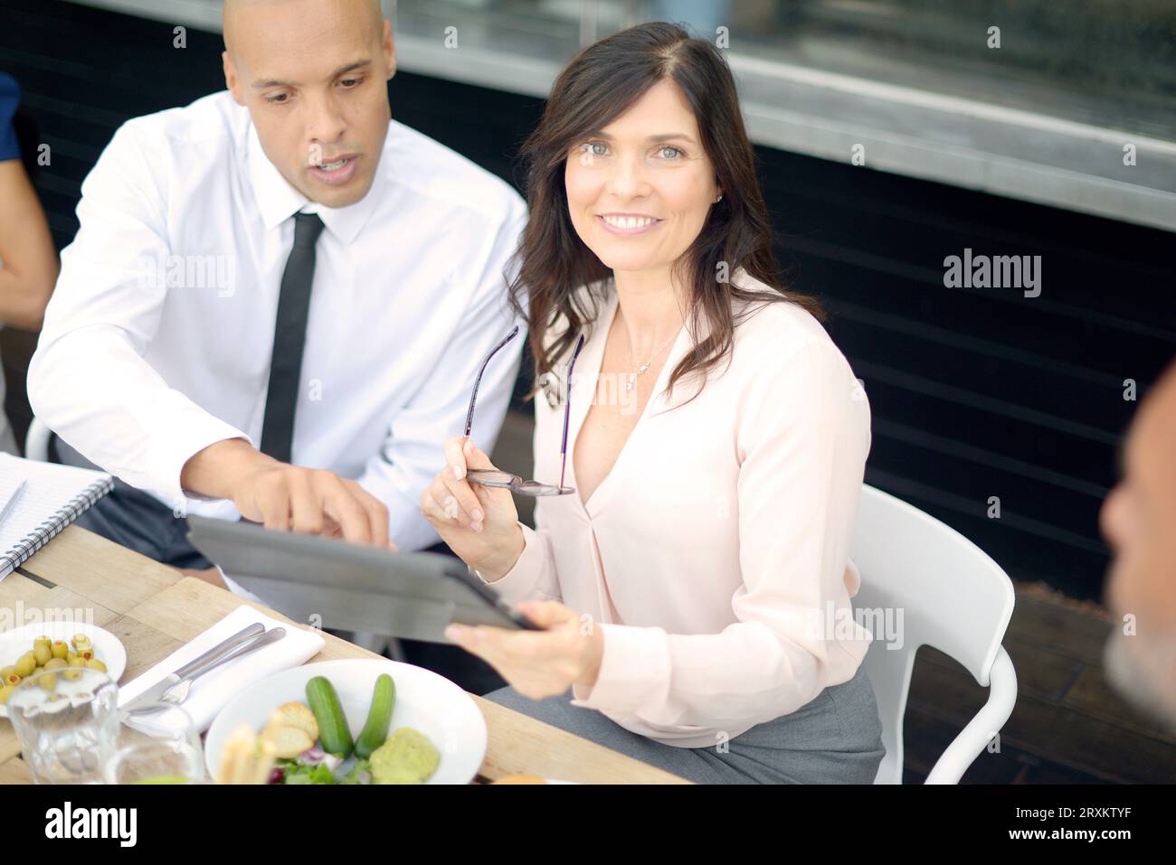Businesspeople using tablet PC at restaurant meeting Stock Photo