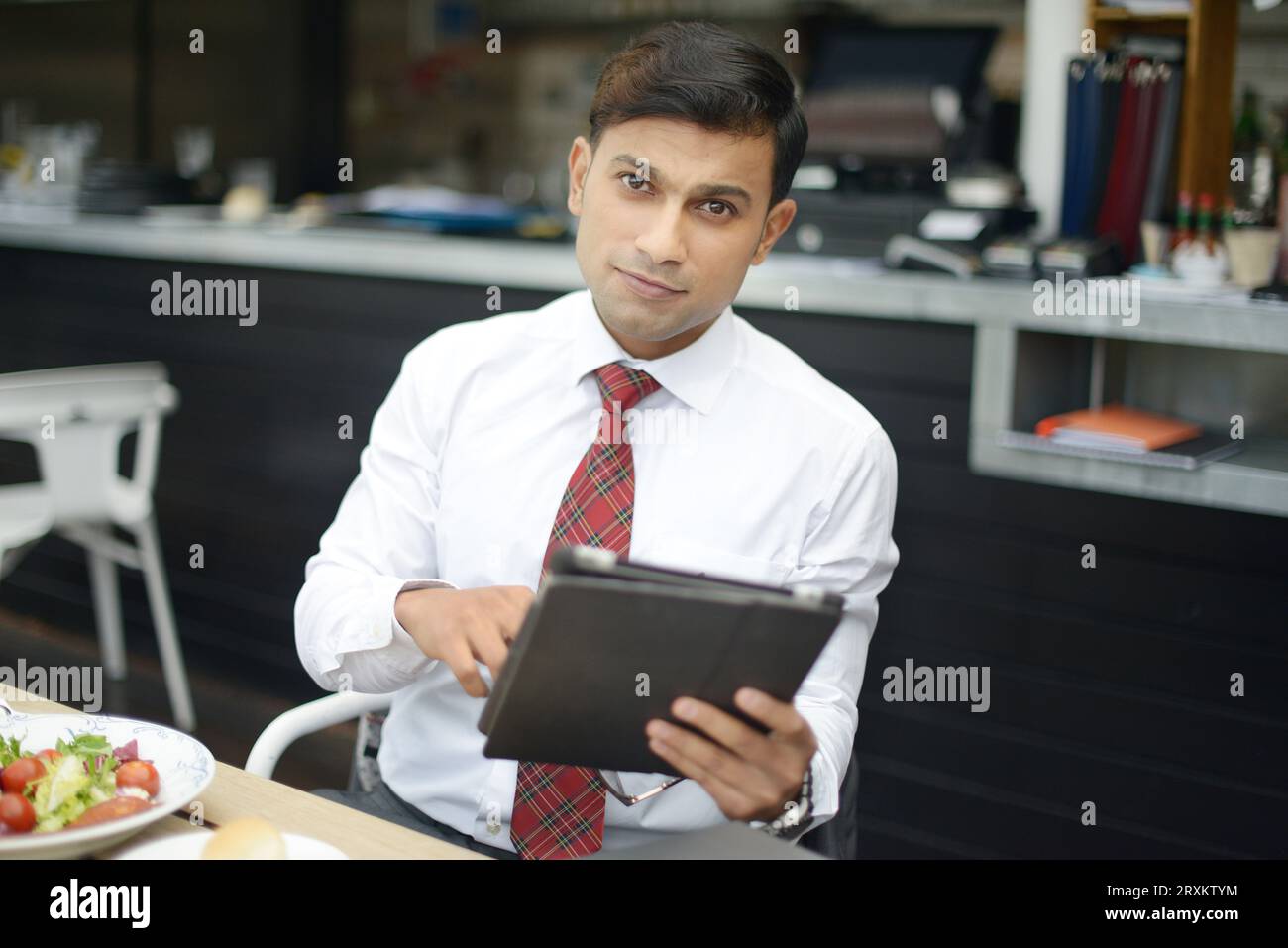 Businessman holding tablet PC at restaurant Stock Photo
