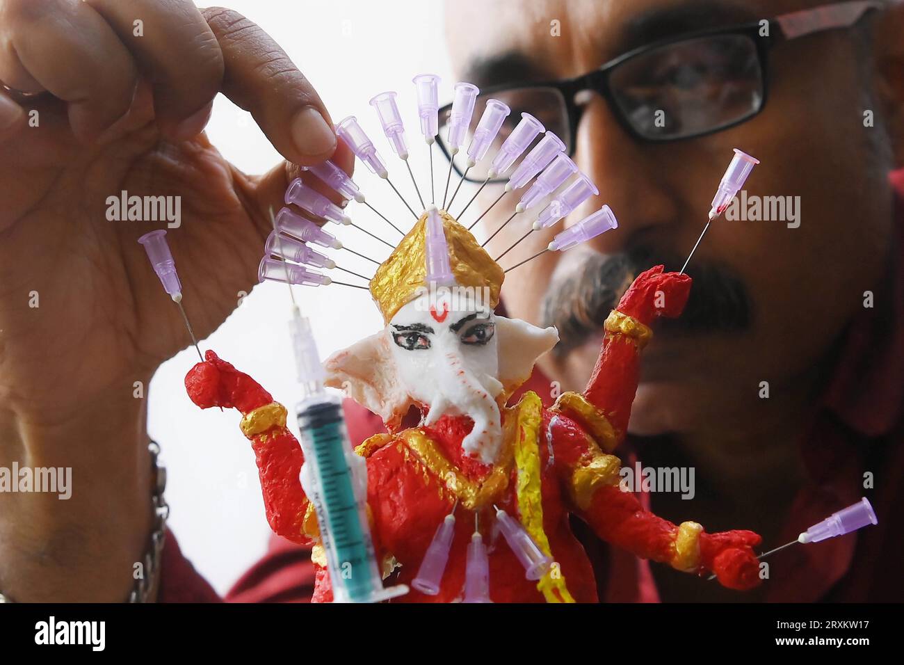 Samiran De, an artist works on an idol of Lord Ganesha made with soup and syringe needles to alert people against drugs, ahead of Ganesh Chaturthi festival, in Agartala. Tripura, India. Stock Photo