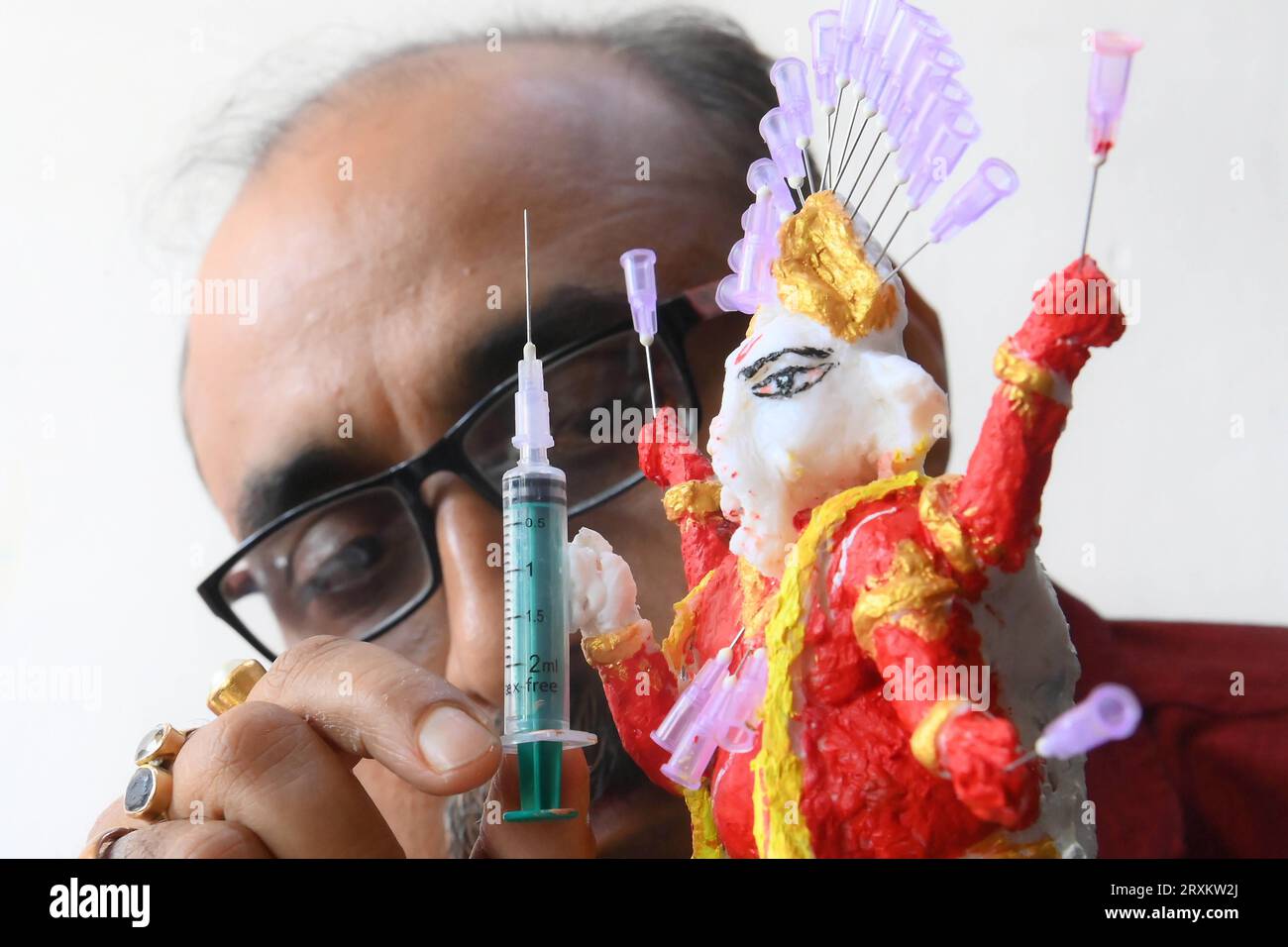 Samiran De, an artist works on an idol of Lord Ganesha made with soup and syringe needles to alert people against drugs, ahead of Ganesh Chaturthi festival, in Agartala. Tripura, India. Stock Photo