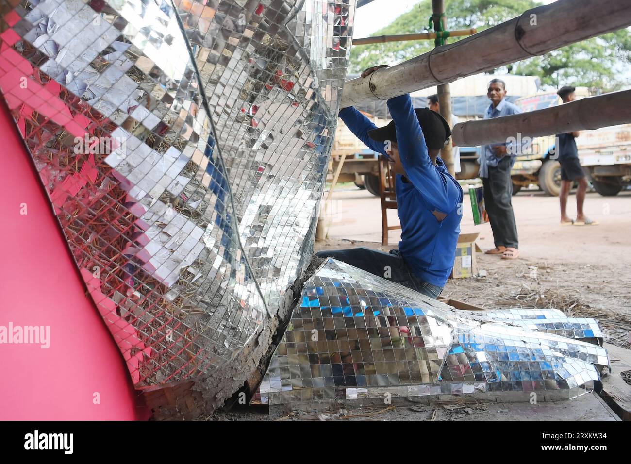 An artist is pasting glass pieces to make a 41 feet tall Ganesh idol, fully covered by glass, ahead of Ganesh Chaturthi festival in a pandal in Ranir bazar. Agartala. Tripura. India. Stock Photo