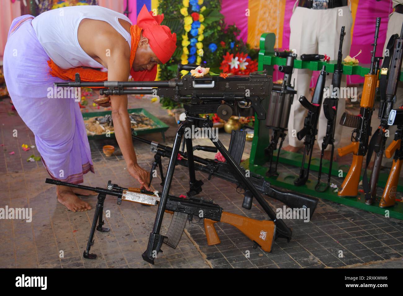 A priest performs worship of arms on Vishwakarma Puja in a TSR (Tripura State Rifles) camp on the outskirts of Agartala. According to Hindus, Vishwakarma is the Divine Engineer of the world. On this day, Hindu people worship their vehicles, tools, machineries etc and celebrate them. Tripura, India. Stock Photo