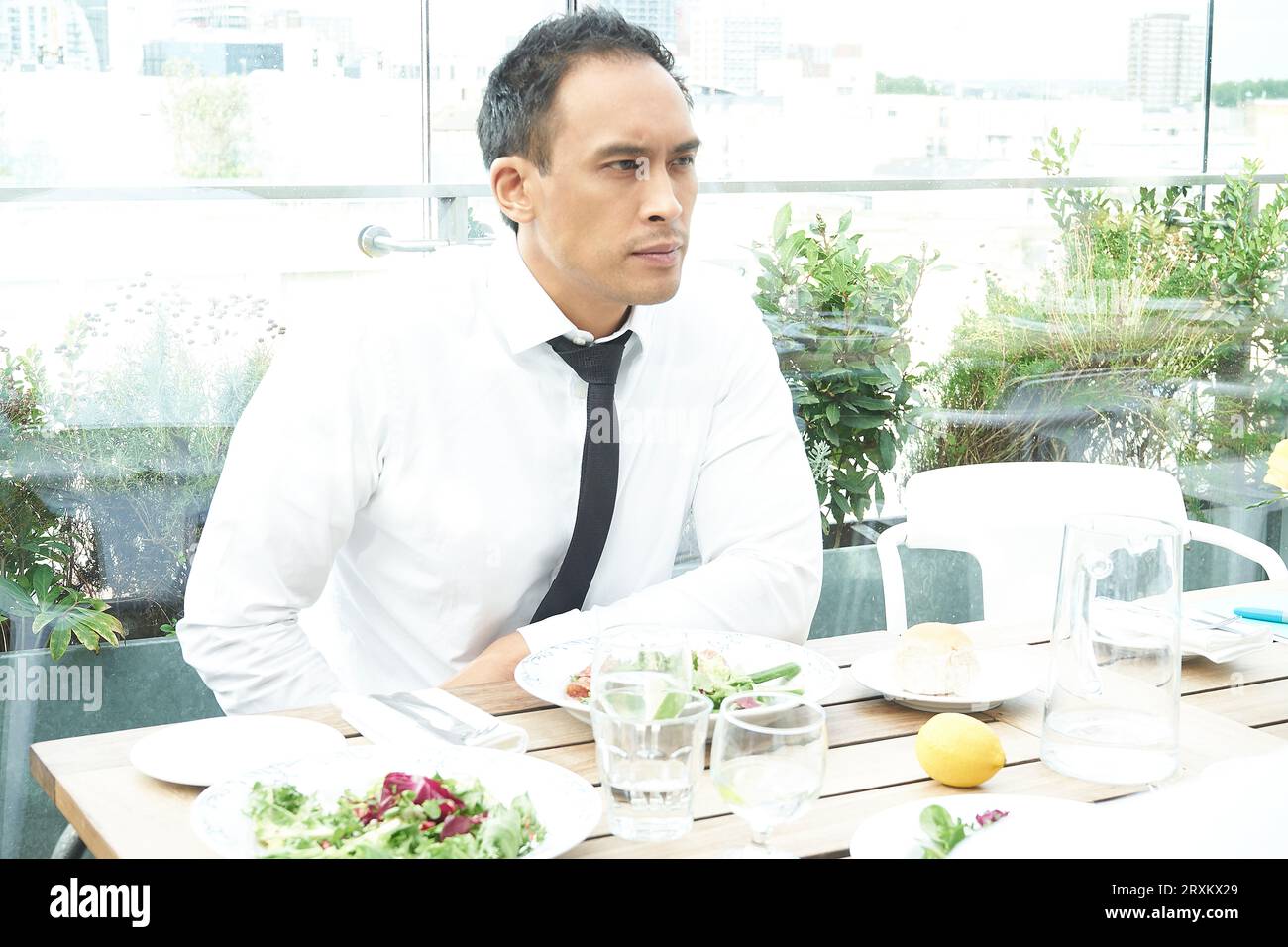 Businessman at a restaurant dining table by a window Stock Photo