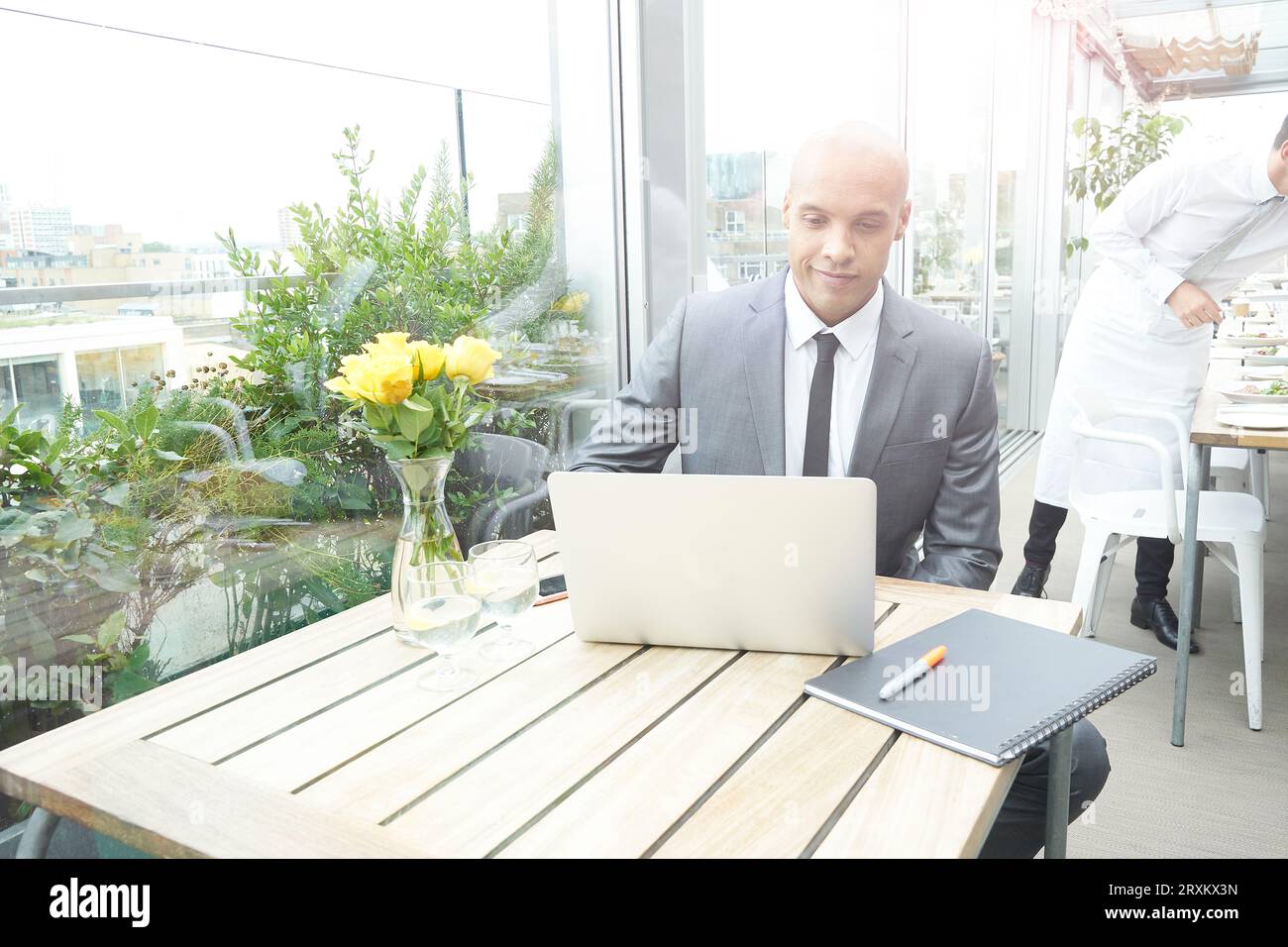Businessman using laptop at restaurant table Stock Photo