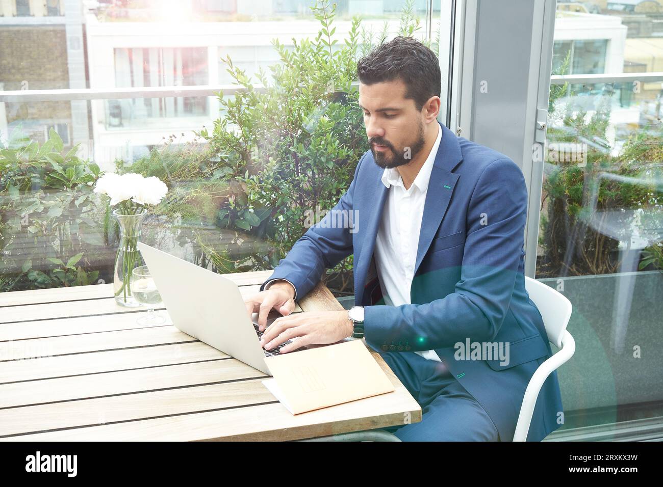 Businessman using laptop at restaurant table Stock Photo
