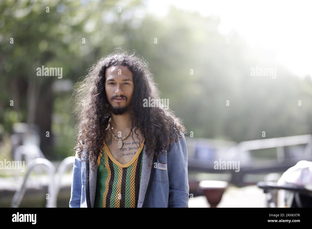 Man with curly hair standing outdoors Stock Photo
