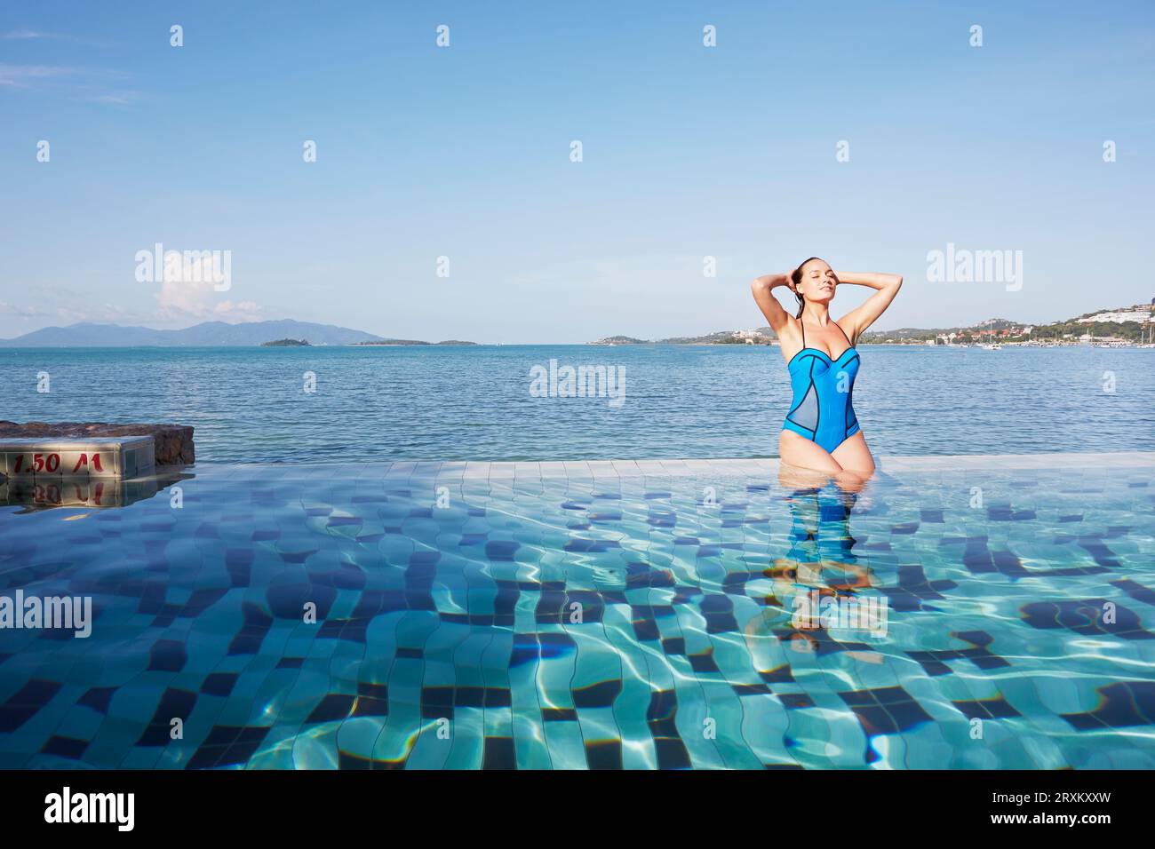 Young woman sitting poolside in Ko Samui, Thailand Stock Photo