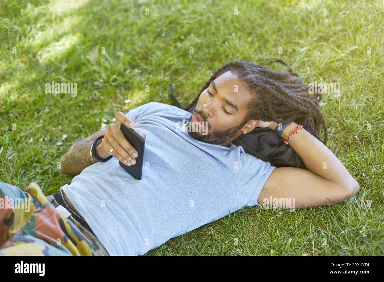 Young man lying in grass Stock Photo