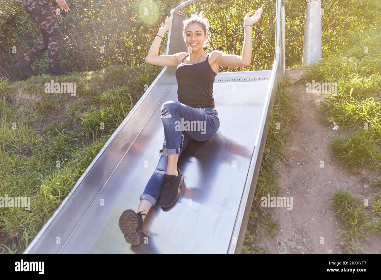 Young woman playing on slide Stock Photo