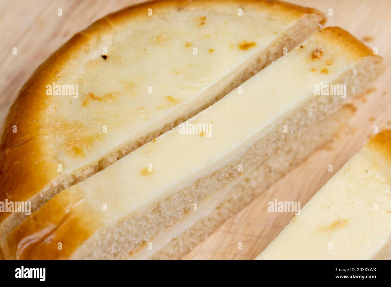 Cut into pieces round bun with creamy sour cream filling, sour cream bun for tea Stock Photo
