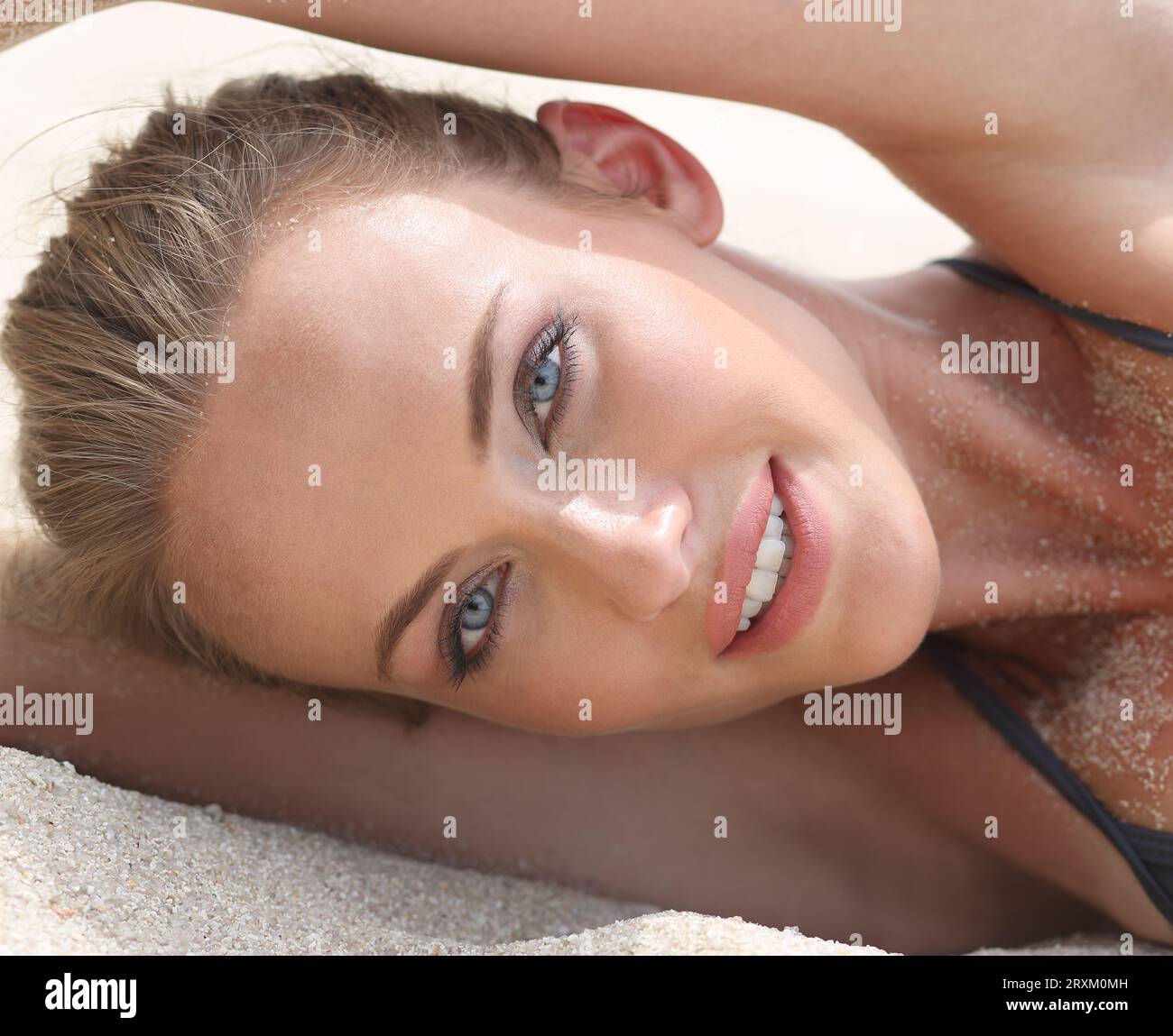 Woman lying on a sandy beach Stock Photo