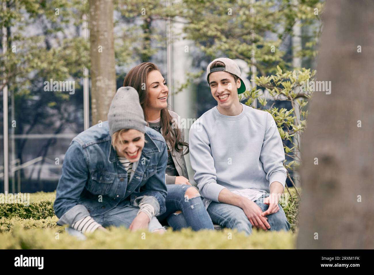 Laughing teenagers sitting park hi-res stock photography and images - Alamy