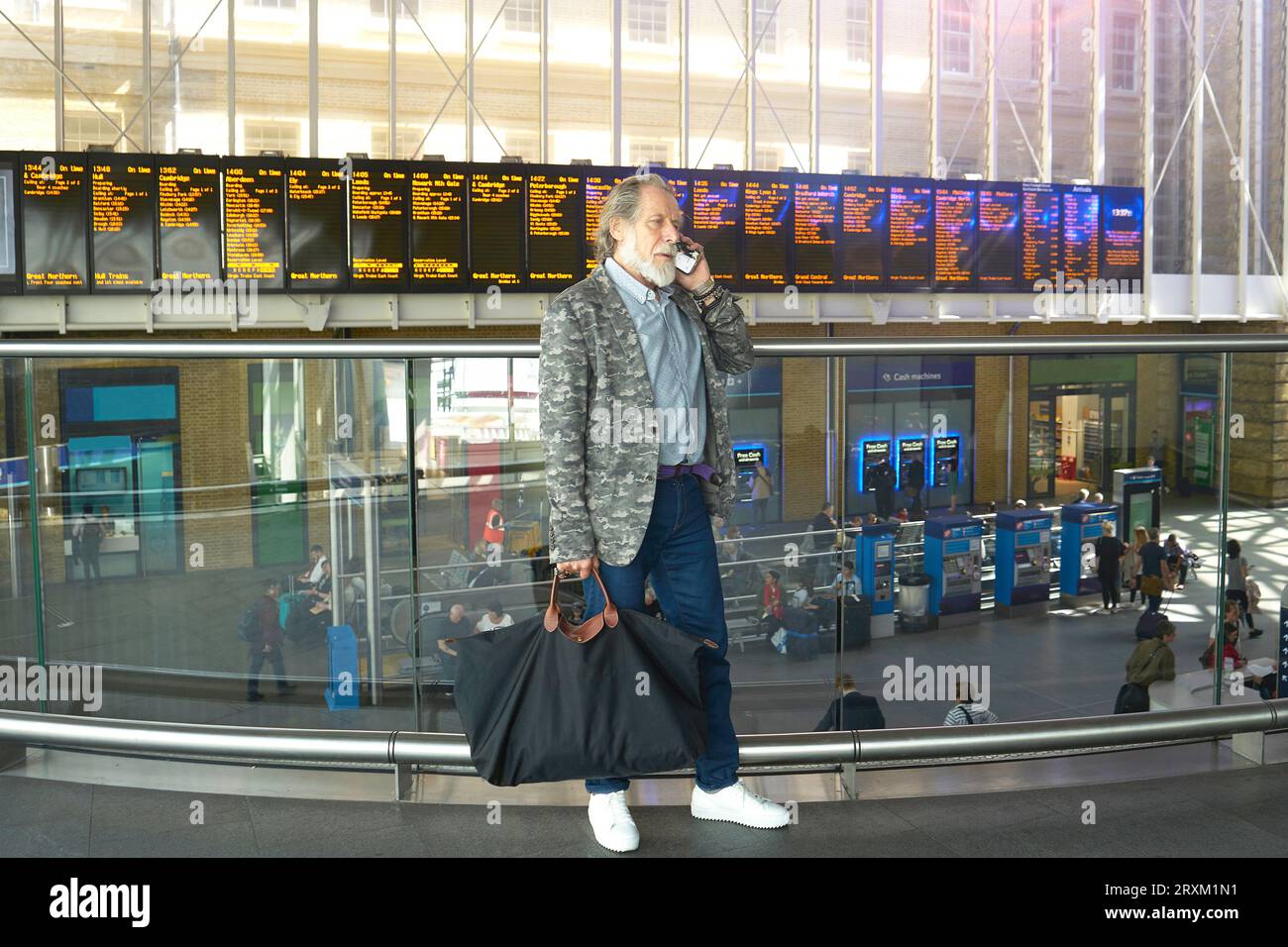 Senior man using mobile phone in train station Stock Photo