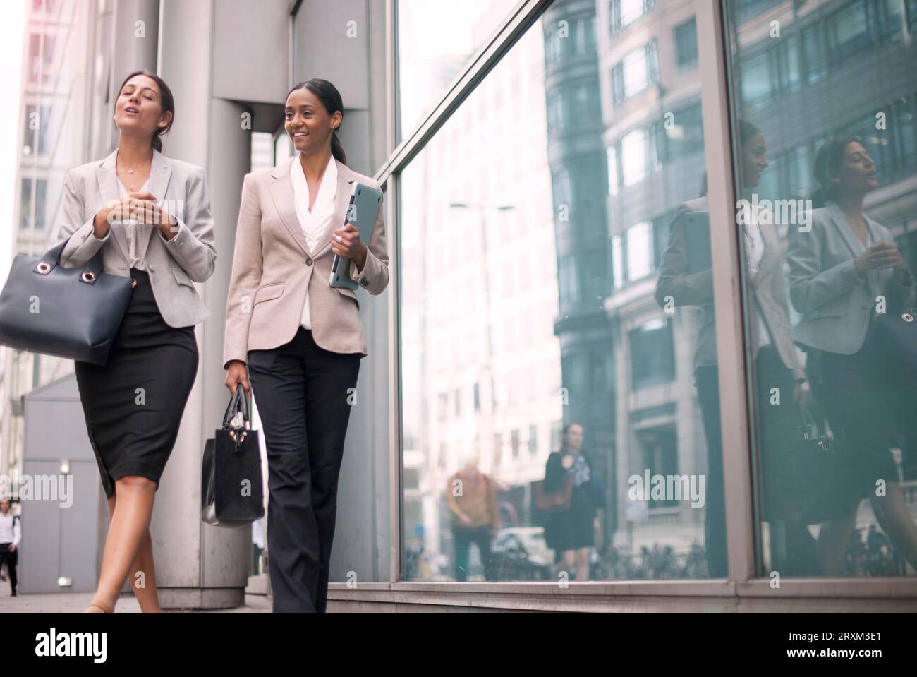 Businesswomen walking on sidewalk Stock Photo