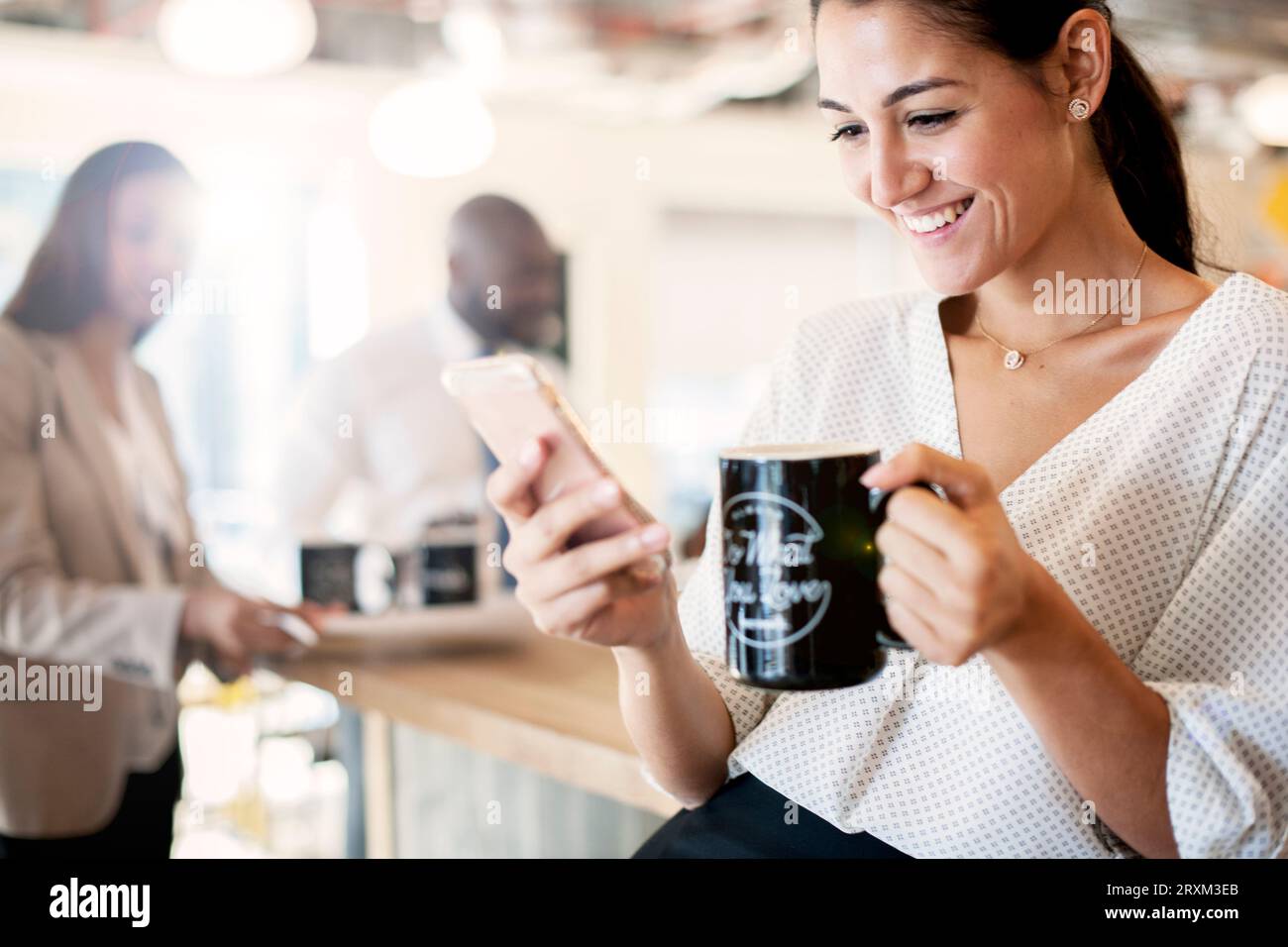 Businesswoman holding coffee cup and smart phone Stock Photo