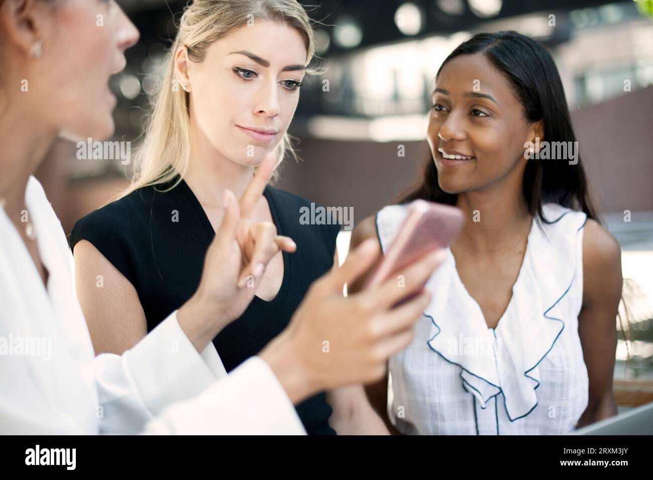 Colleagues using smart phone Stock Photo