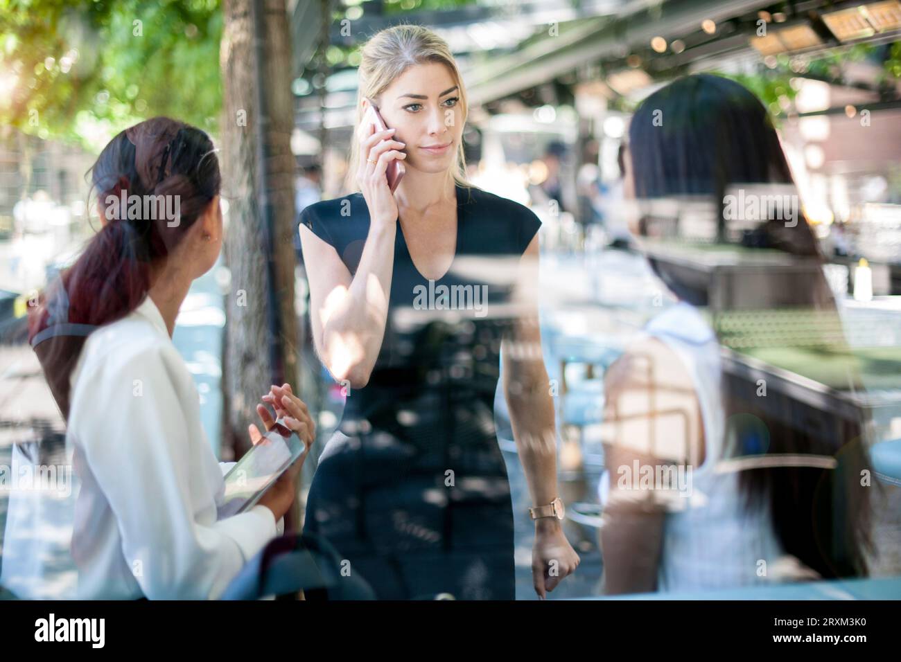 Businesswoman on phone by colleagues Stock Photo