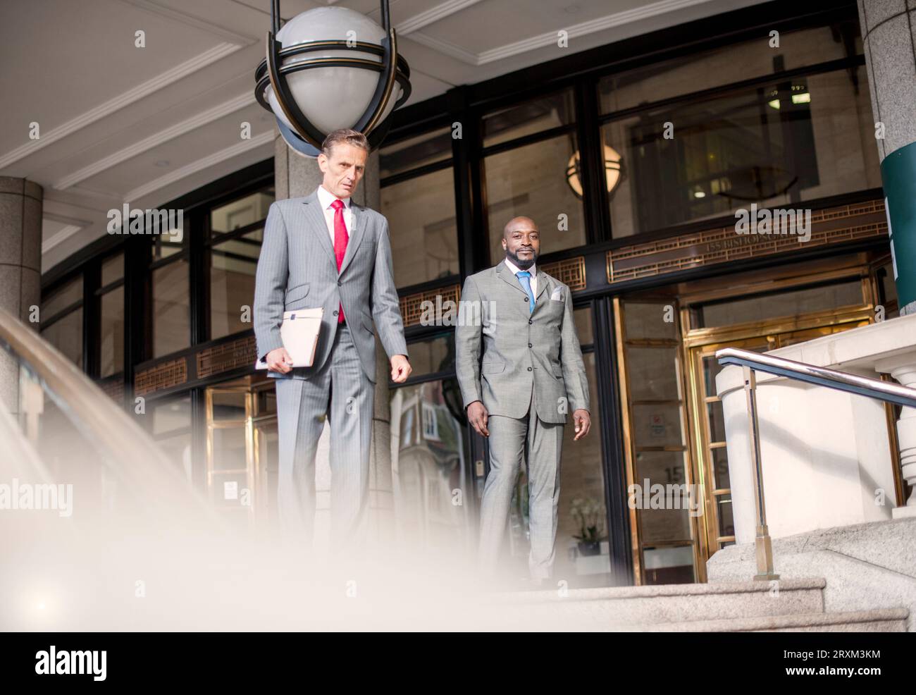 Businessmen wearing suits outside building Stock Photo