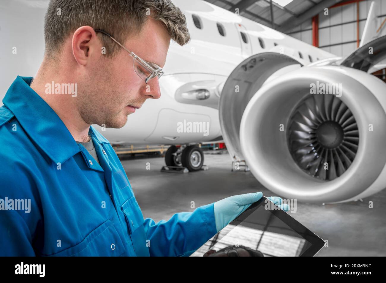 Young man using digital tablet by airplane Stock Photo