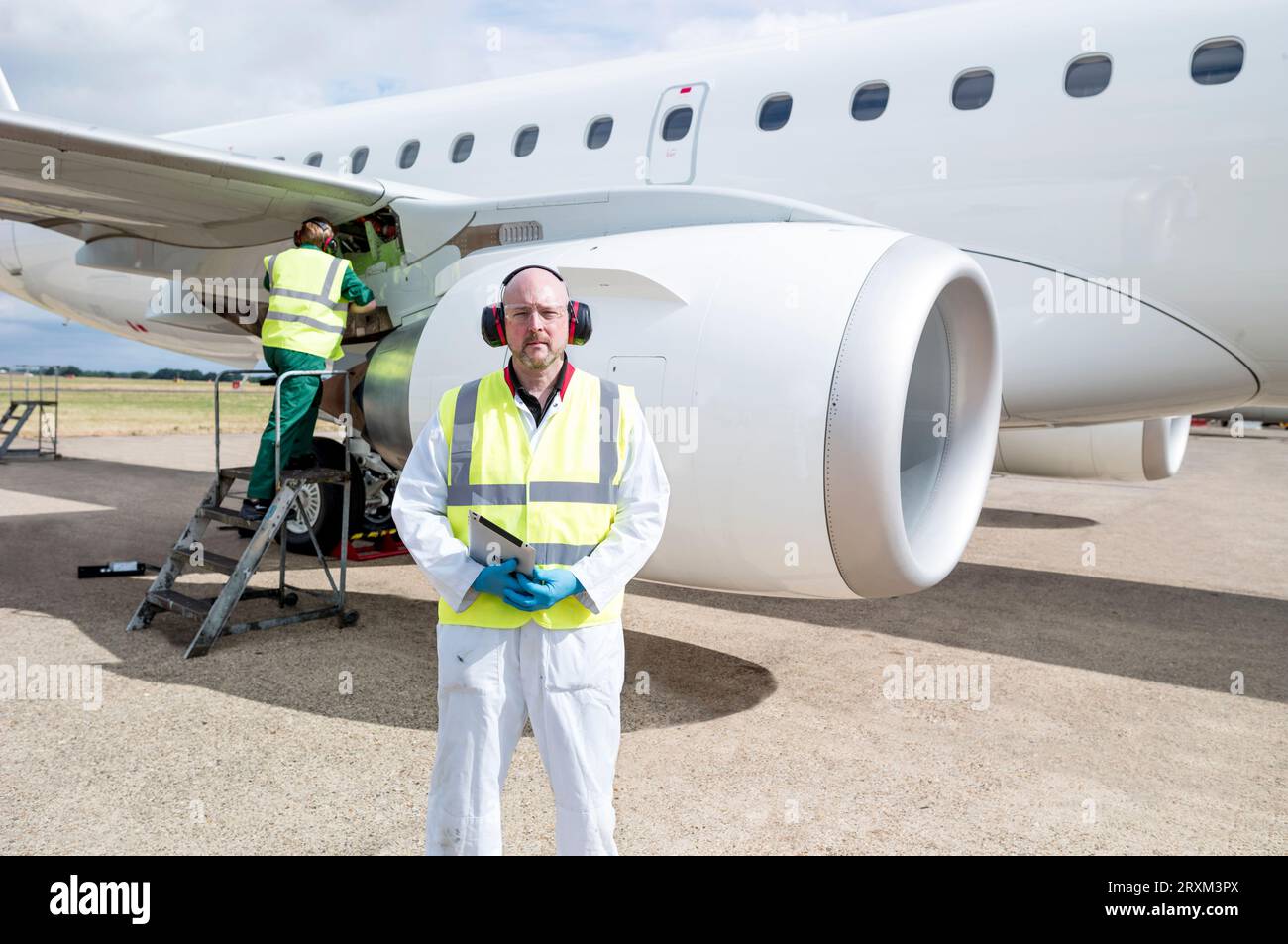 Middle aged man holding digital tablet by airplane Stock Photo