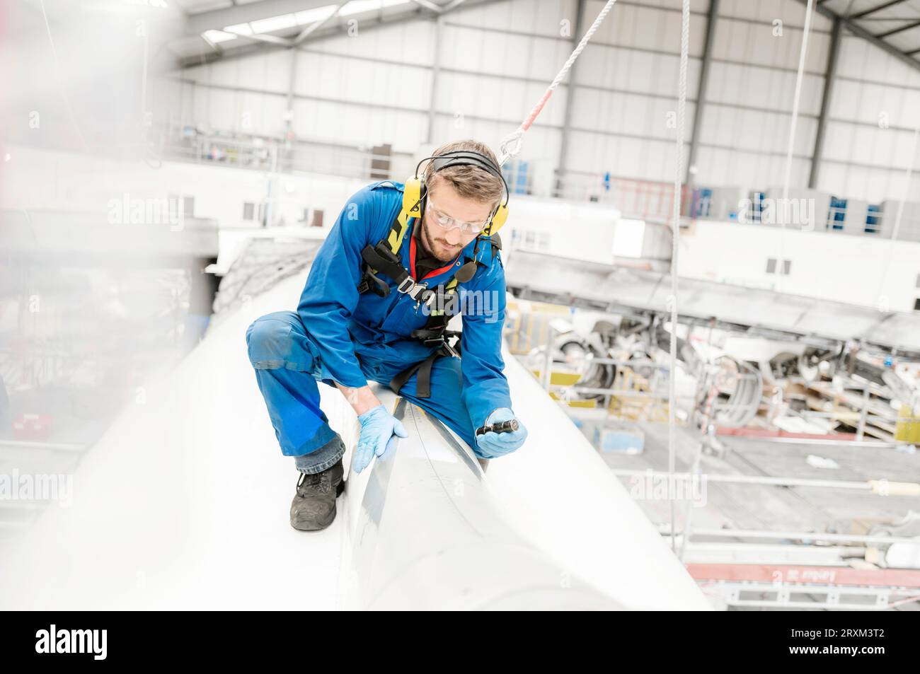 Man shining torch on airplane in hangar Stock Photo Alamy