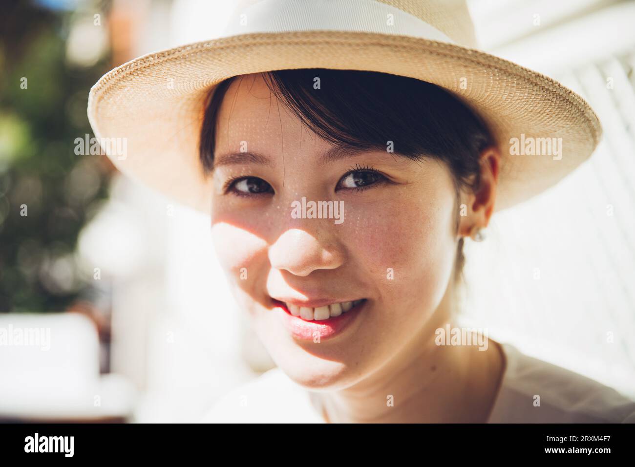 Smiling young woman wearing straw hat Stock Photo