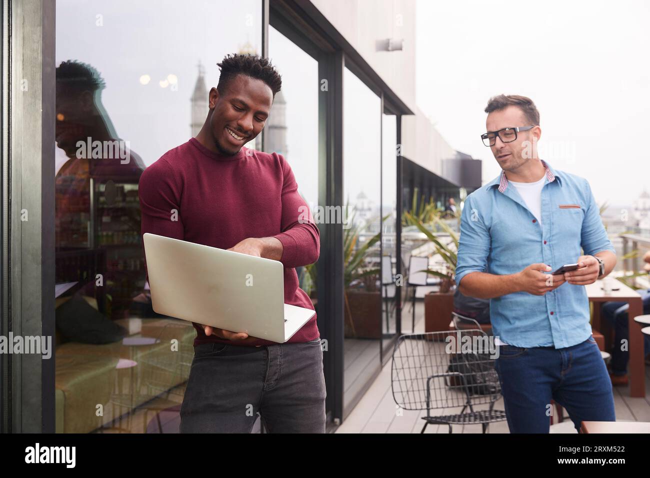 Businessmen using laptop on balcony Stock Photo