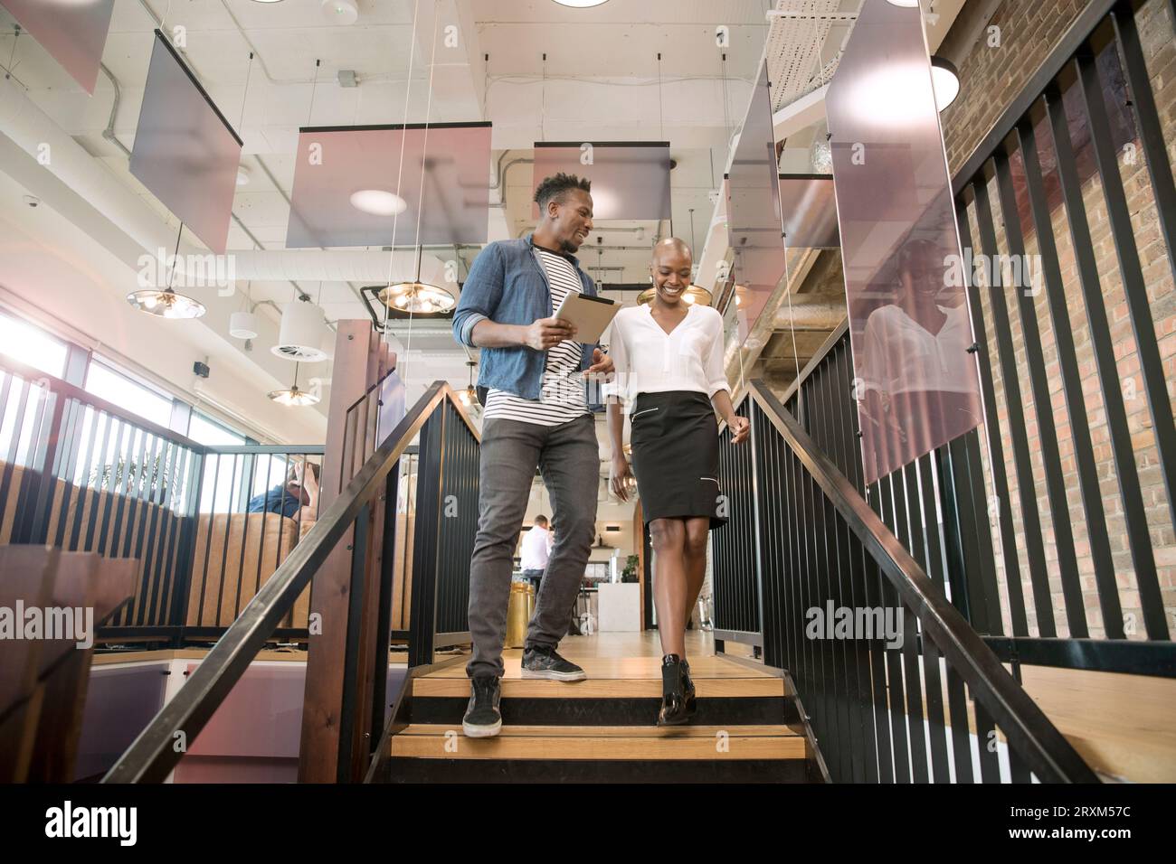 Colleagues using digital tablet on staircase Stock Photo
