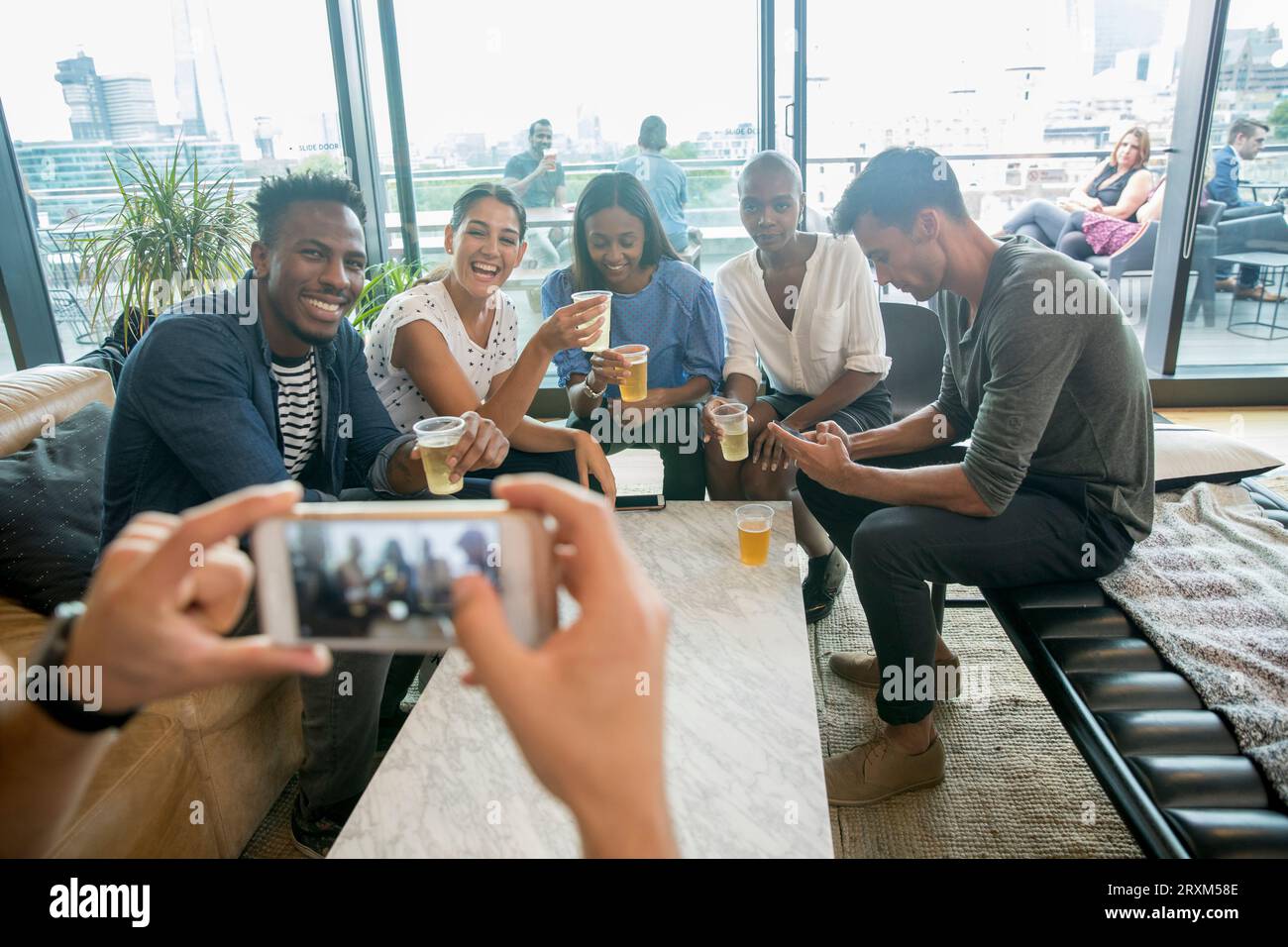 Colleagues posing for photograph with drinks Stock Photo
