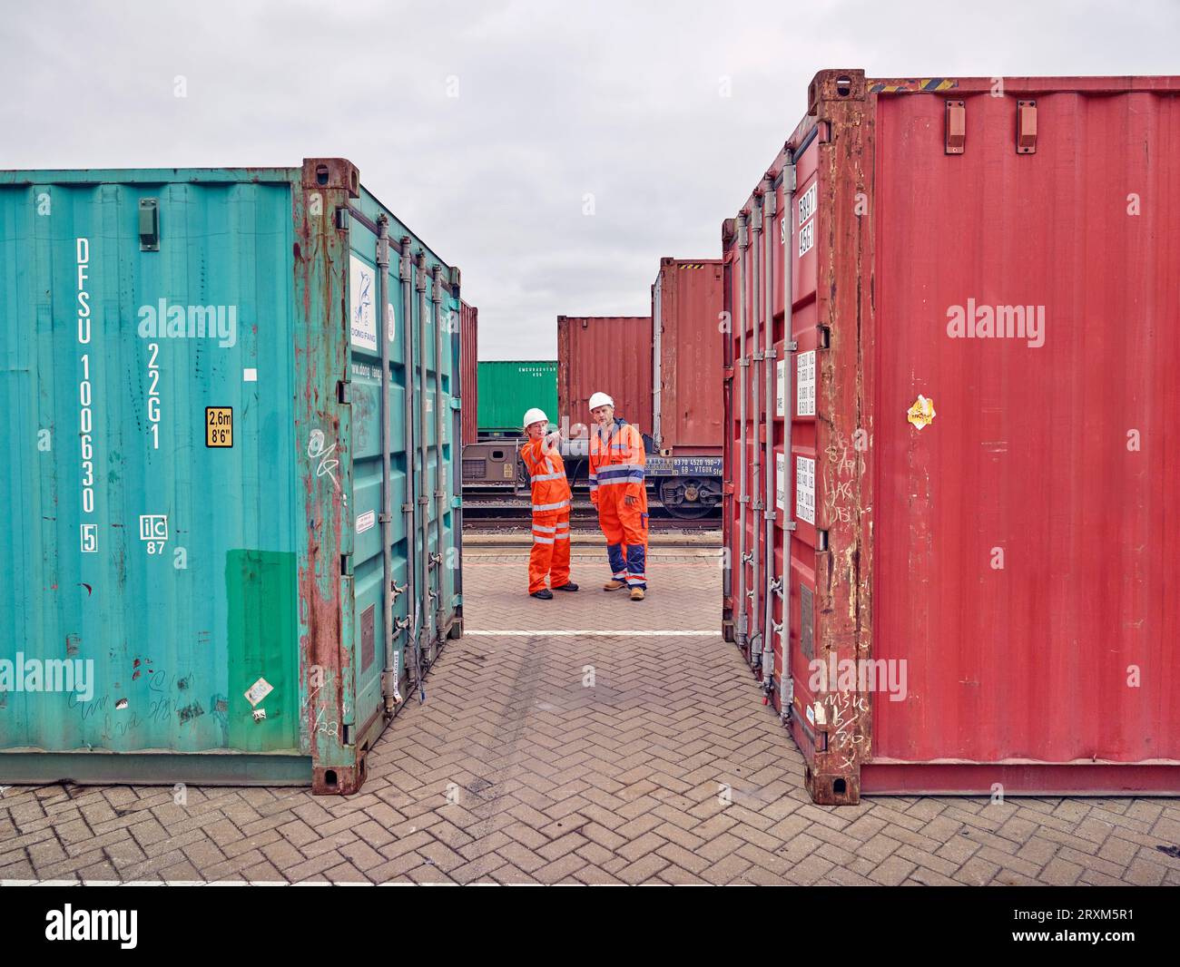 Dock workers between cargo containers at Port of Felixstowe, England