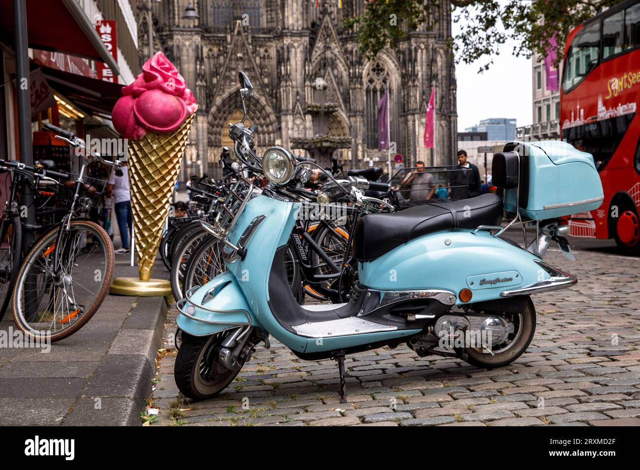 motor scooter and large ice cream cone in front of an ice cream parlor on the street Burgmauer near the cathedral, Germany. Motorroller und grosse Eis Stock Photo