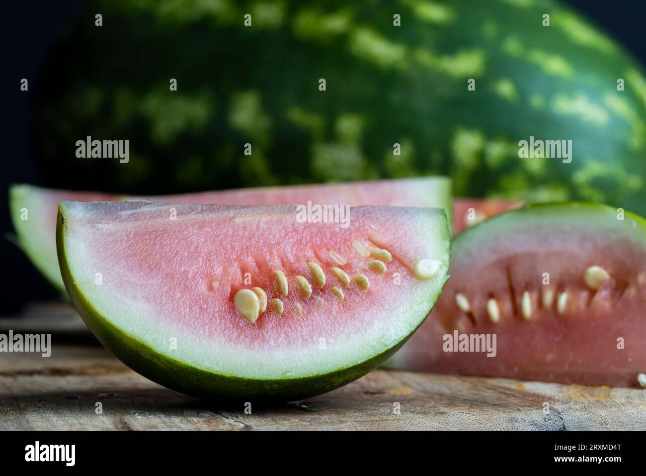 Unripe watermelon of small size with large white seeds and light pink flesh, not sweet not ripe cut watermelon Stock Photo