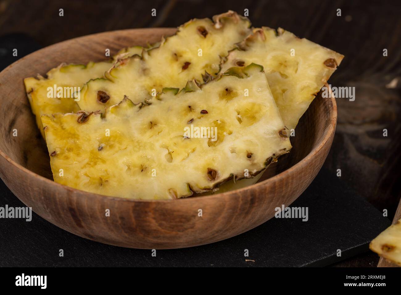 ripe pineapple of yellow-orange color cut into a large number of pieces, preparation of ripe peeled pineapple Stock Photo