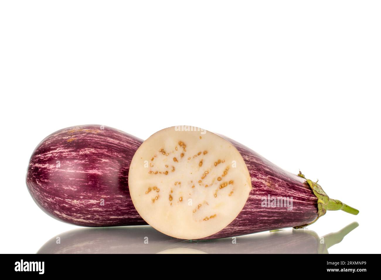 One whole and one half juicy eggplant, macro, isolated on white