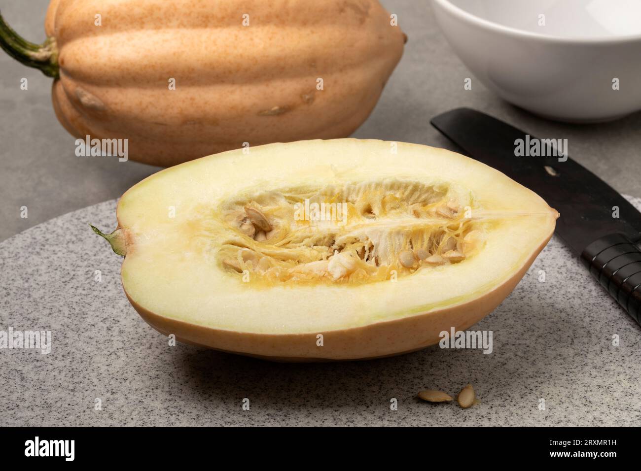 Whole and halved fresh Baked potato Acorn Squash on a cutting board close up Stock Photo