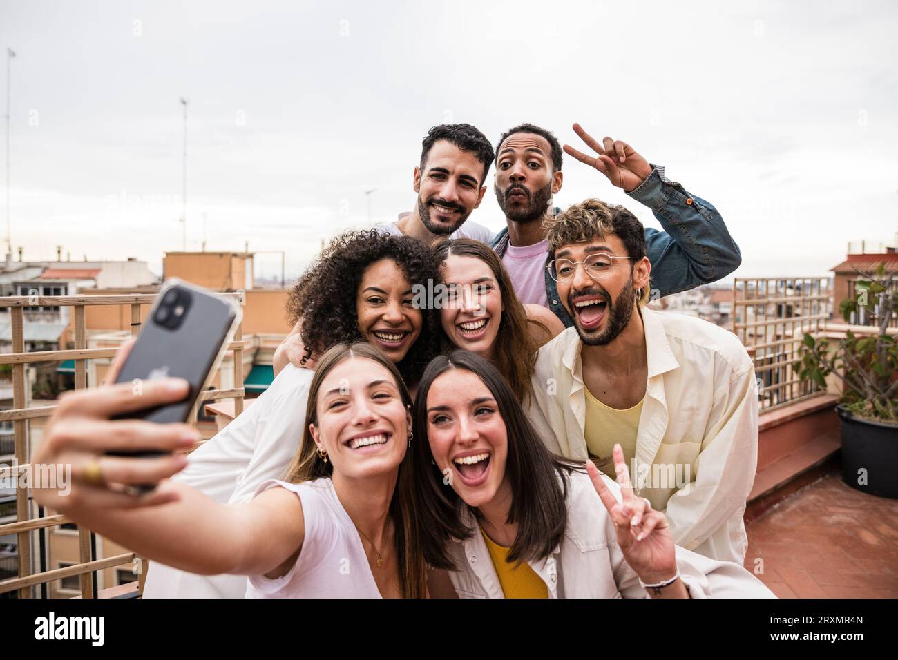 Diverse joyful group of carefree friends having fun and taking a selfie ...