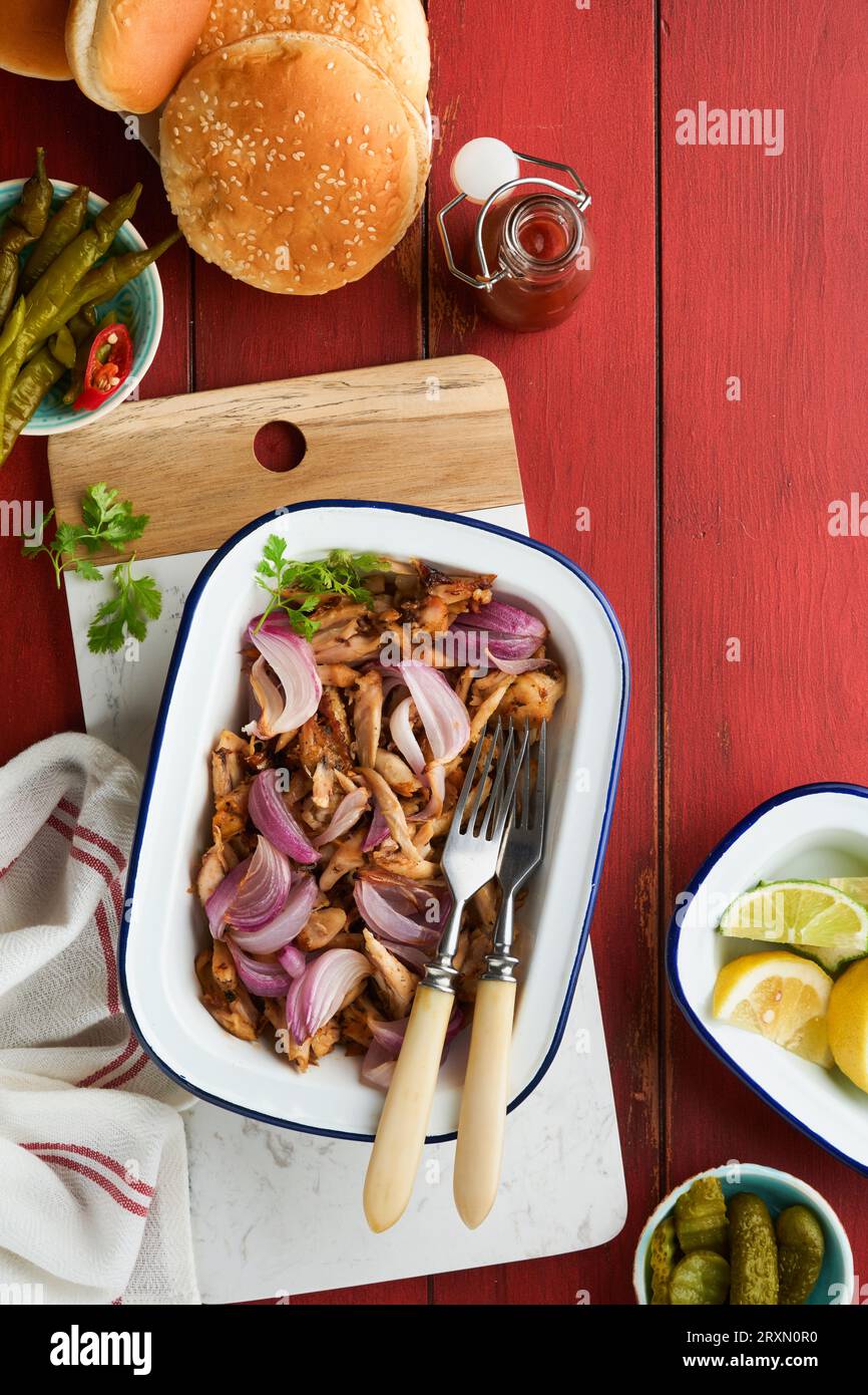 Pulled bbq chicken with baked onions on serving platter, bbq corn