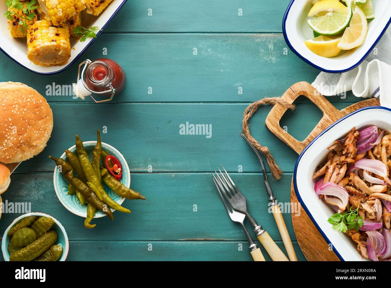 Pulled bbq chicken with baked onions on serving platter, bbq corn