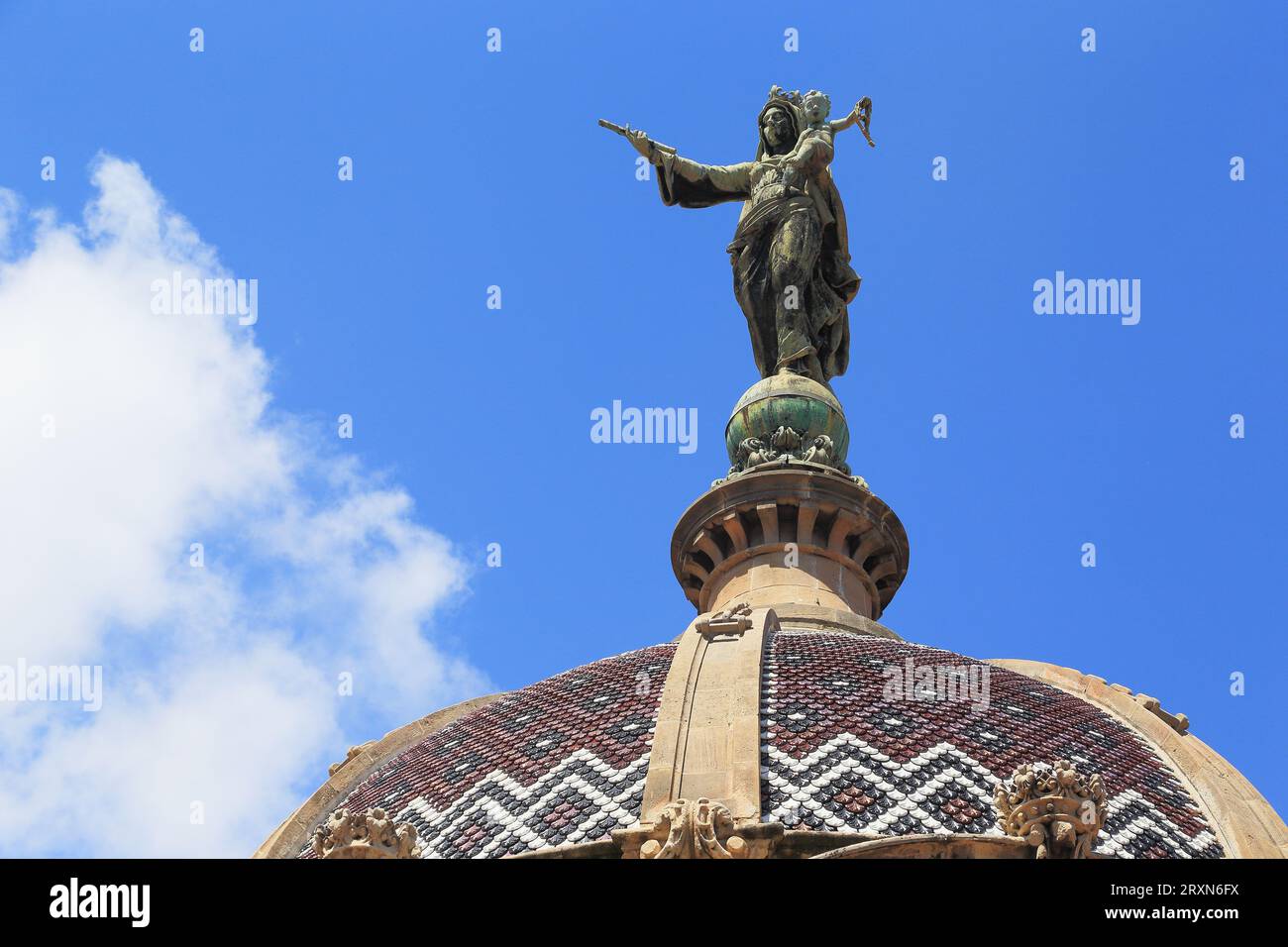 BARCELONA, SPAIN - MAY 11, 2017: This is a huge bronze figure of the Virgin and Child, crowning the dome of the Basilica de la Merce. Stock Photo