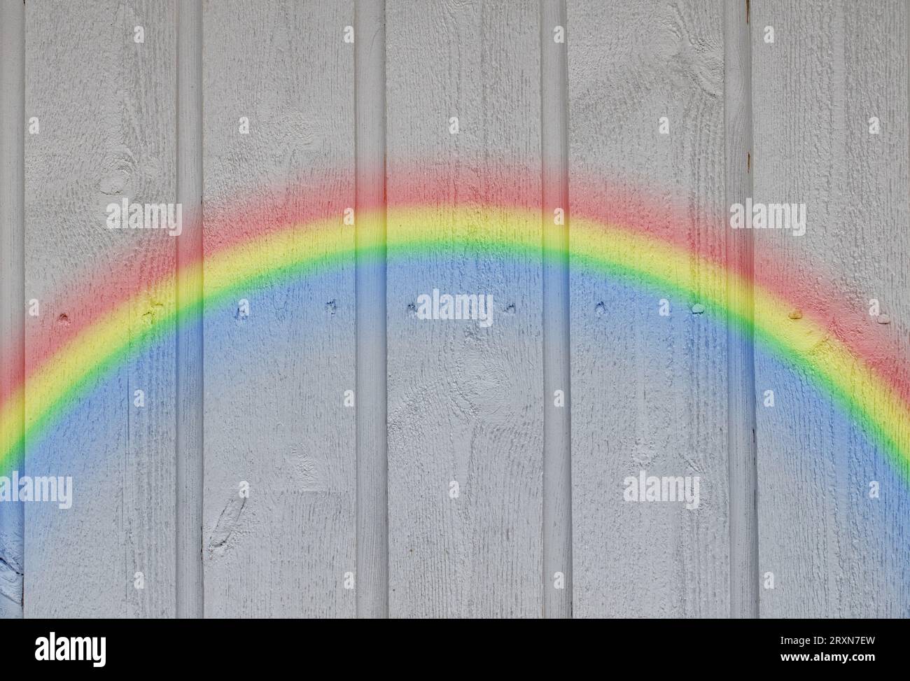 Wooden wall background with a rainbow Stock Photo