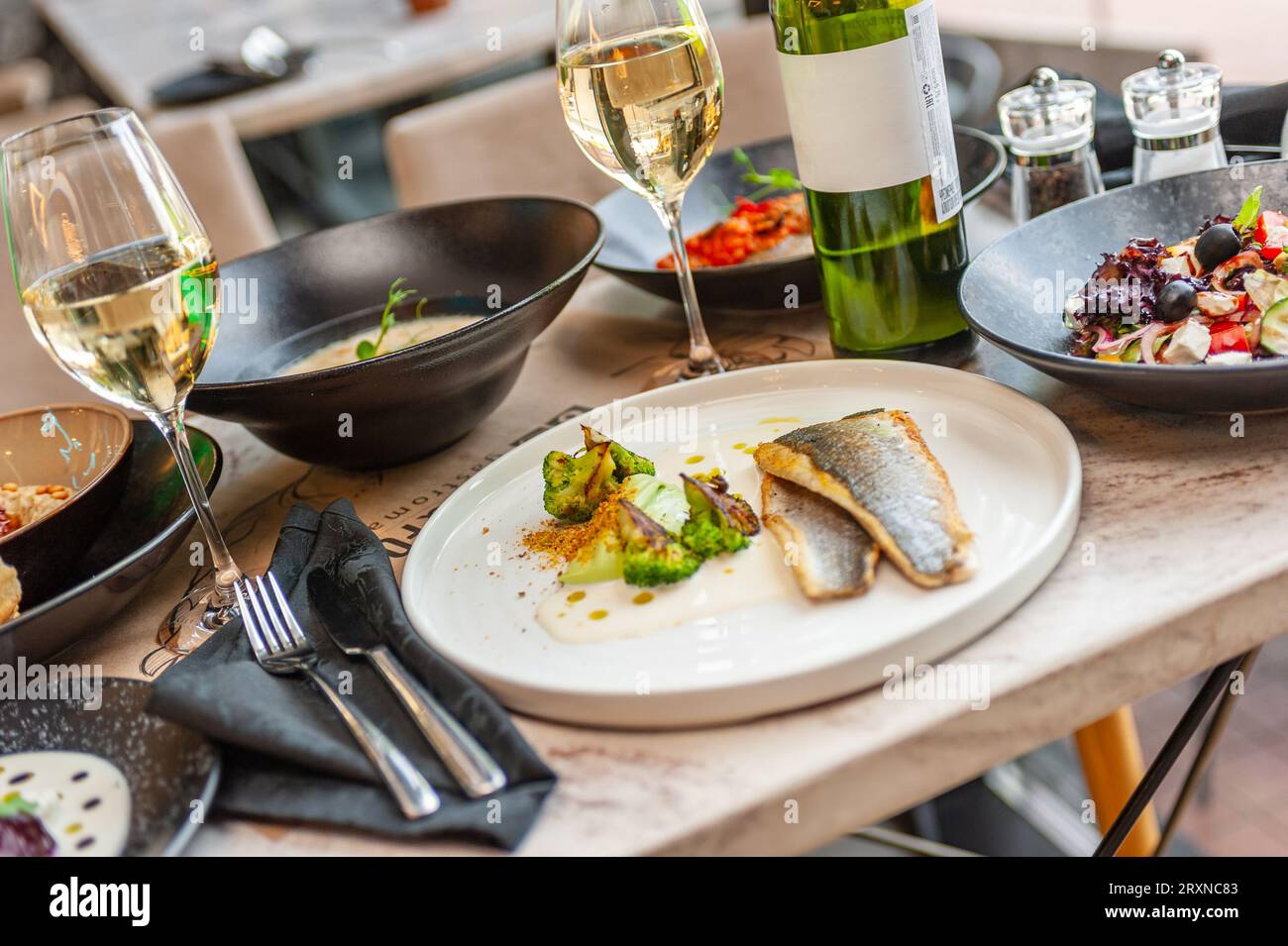 Dorado or sea bass fillet in cream sauce with broccoli on a white plate. High quality photo Stock Photo