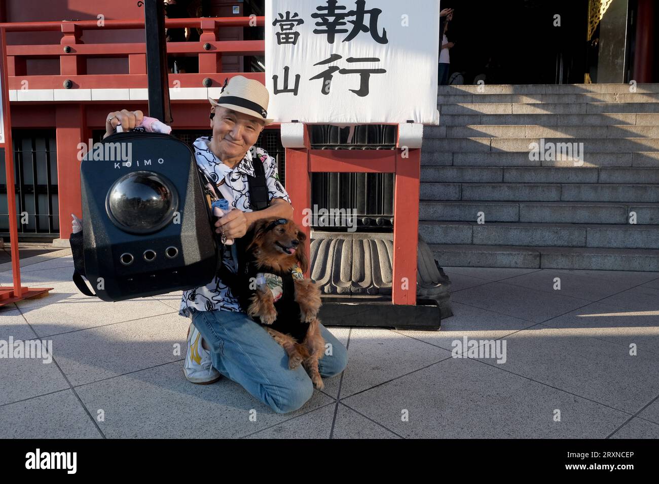 An elderly Japanese male street performer poses with his dog in  Asakusa,Tokyo, Japan Stock Photo
