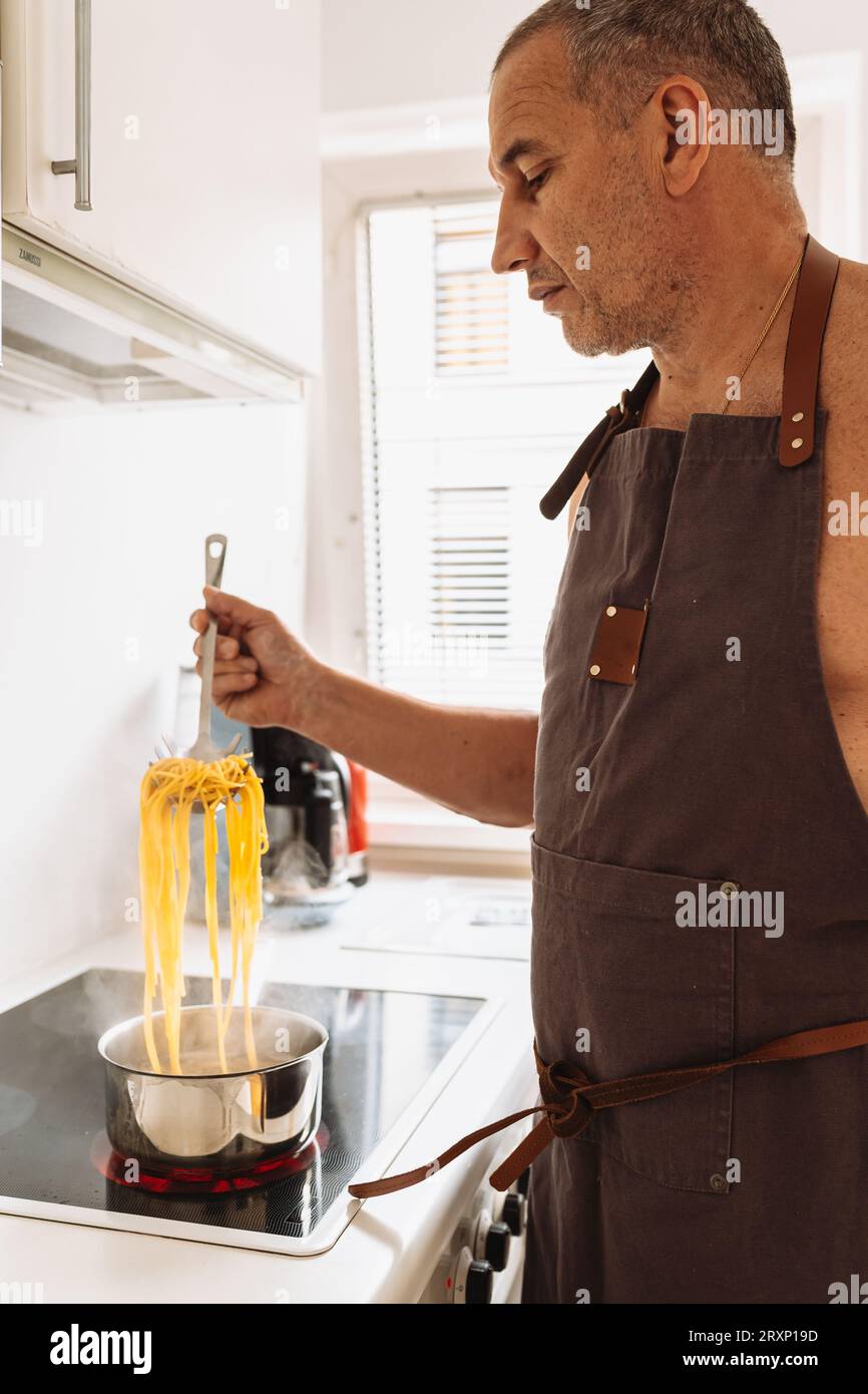 Pasta cooking hand pot water home hi-res stock photography and images ...