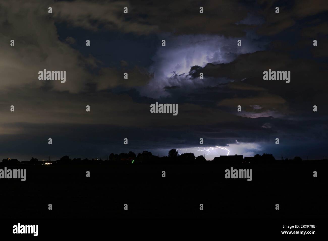 Thunderstorm is illuminated by lightning Stock Photo