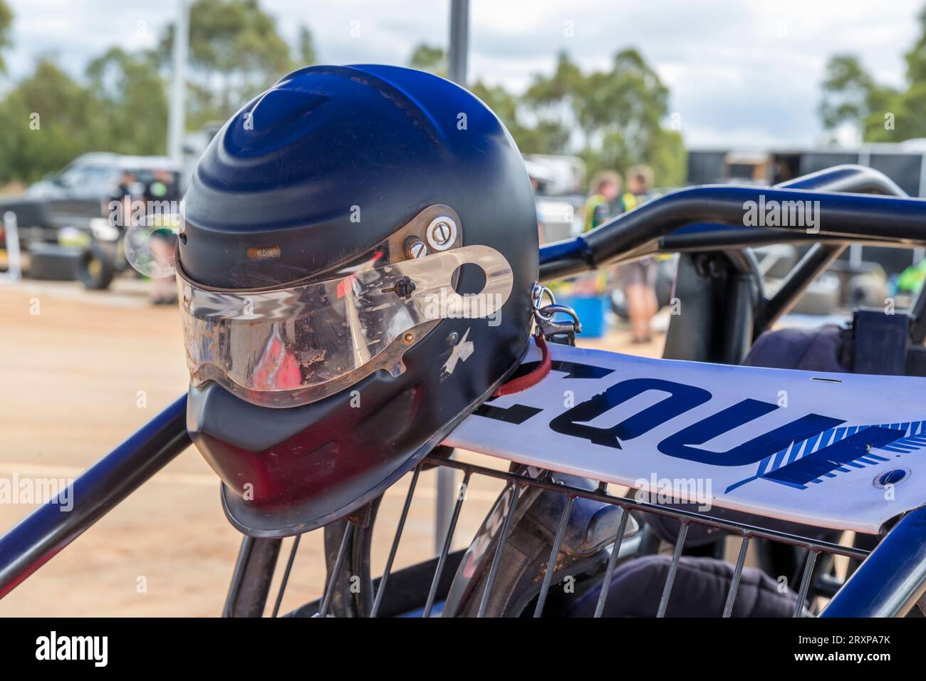 Photograph of a wellworn helmet hanging on the driver protection cage