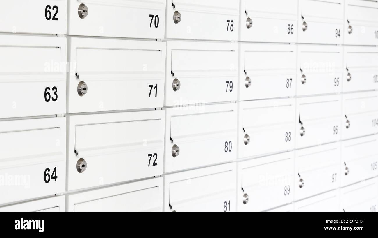 Lots of white private mailboxes, wall of many letterboxes in a flat