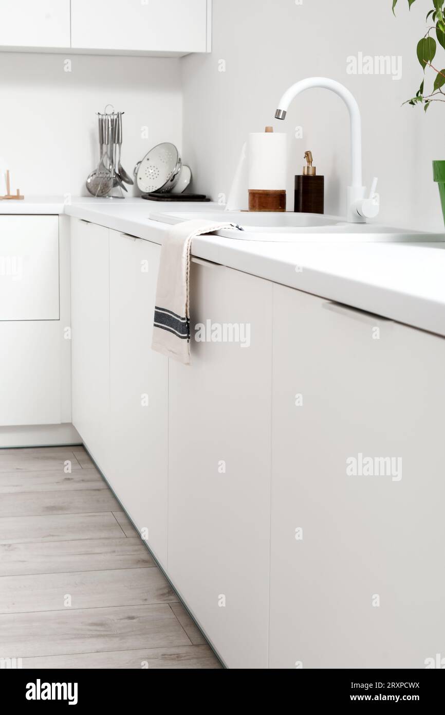 White counters with sink and utensils in light kitchen Stock Photo - Alamy